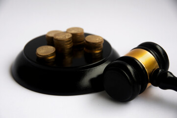Lawyer gavel on white cover with gold coins background. Law concept