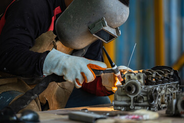 Industrial welder worker metal welding steel works using argon arc welding machine to weld steel at...