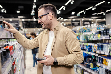 A man choosing deodorant at supermarket.