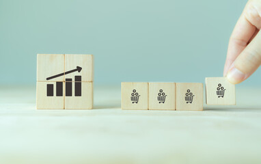 Growth of sales, average order value (AOV) concept. Strategy to get more money per oder. Increase sales in online store, e-commerce. Adding wooden cubes with sales growth on grey background.