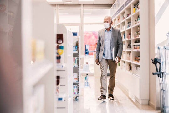 A senior man shopping vitamins in pharmacy during covid 19.