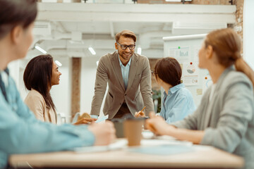 Happy man talking to his female colleague during a meeting