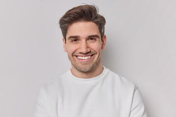 Portrait handsome man with dark hairstyle bristle and toothy smile dressed in white sweatshirt...
