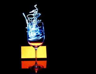 Light painting on a mirror with reflections and a wine glass