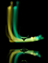 Light painting on a mirror with reflections and a wine glass