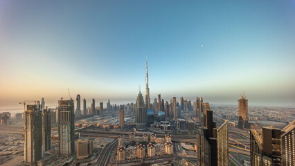 Naklejka premium Aerial view of tallest towers in Dubai Downtown skyline and highway timelapse.