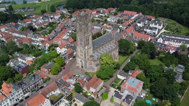High altitude aerial footage of the Saint Martin church in Zaltbommel is a municipality and a city in the Netherlands in the background showing Waal river a branch of river Rhine 4k resolution