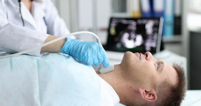 Man is checked for thyroid gland on ultrasound machine in hospital