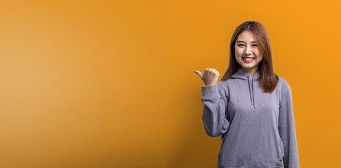 Portrait of Asian woman gesturing pointing at empty space for ad text, portrait concept used for...
