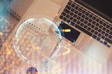 Double exposure of map hologram drawing over study table background with computer. Concept of international network. Top view.