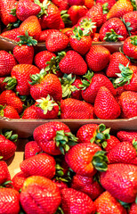 A stall in the market with strawberries in boxes.