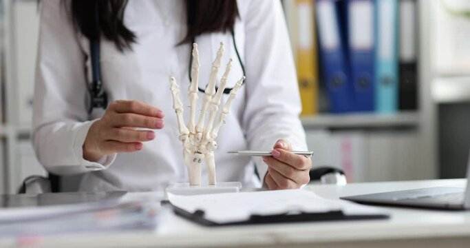 Surgeon shows anatomy of skeleton of hand closeup