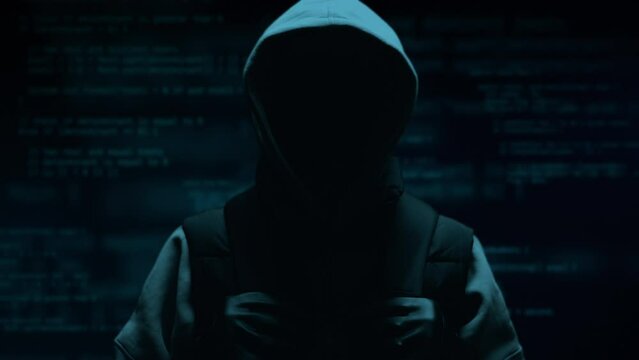 Computer hacker with hoodie. Computer abstract digital code at the background. Darknet fraud and cryptocurrency bitcoin concept. Cybersecurity and data protection in social network