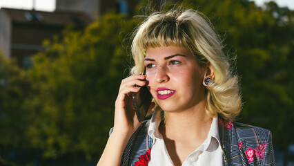 La comunicación y beneficios del teléfono móvil en la actualidad, Mujer feliz hablando por el móvil  , chica alegre de pelo corto con un teléfono  en la mano - obrazy, fototapety, plakaty