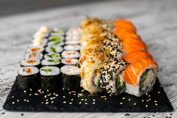 Sushi Set nigiri and sushi rolls on black stone slate plate board top view