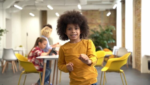 Cheerful boy dancing in the classroom