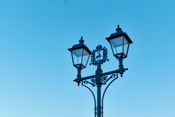 Fototapeta na wymiar Street lamps in retro style with coat of arms of Nizhny Novgorod against blue sky.