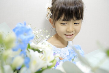 ドレスを着る女子小学生と花束 (7歳)