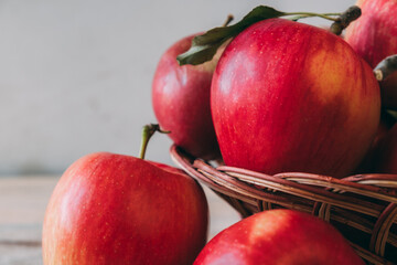 Several red apples in wooden basket close-up. Fresh harvest of apples.