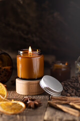 A set of different aroma candles in brown glass jars. Scented handmade candle. Soy candles are burning in a jar. Aromatherapy and relax in spa and home.