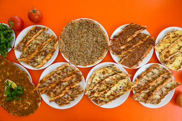  Traditional Turkish cuisine. Pizza, pita, pidesi, sucuk, hummus, kebab. Many dishes on the table. Serving dishes in restaurant. Background image. Top view, flat lay
