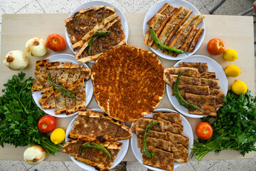  Traditional Turkish cuisine. Pizza, pita, pidesi, sucuk, hummus, kebab. Many dishes on the table. Serving dishes in restaurant. Background image. Top view, flat lay