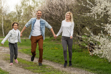 Mother, father and child daughter having fun outdoors