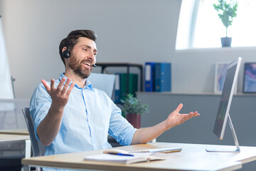 A happy surprised call center employee works in the office with a headset for a video call