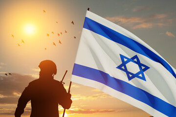 Silhouette of soldier with Israel flag against the sunrise in the desert. Concept - armed forces of...