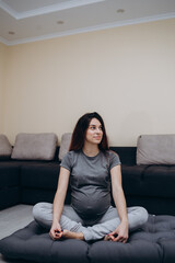 Pregnant Woman Stretching Arms And Legs, Doing Prenatal Workout At Home On Yoga Mat. Selective focus