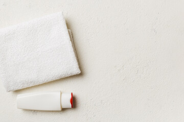 Cosmetic shampoo bottle mockup with towels on a colored table. Bathroom background, toilet accessories for hand and body care