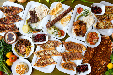 Delicious meat kebab with fresh vegetable salad served with variety of Turkish dishes and appetizers. Top view of assorted Turkish food and meze, tasty and healthy Mediterranean cuisine.