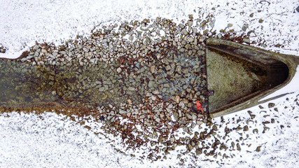 Water drains out of this drain pipe as springtime arrives melting the snow