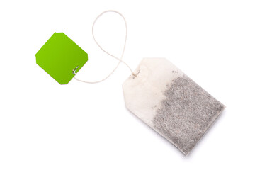 Teabag with green label. Isolated on a white. Tea.