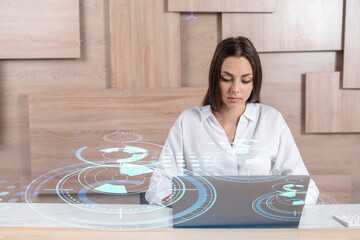 Attractive businesswoman in white shirt at workplace working with laptop to optimize development by...