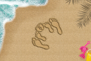 Fototapeta na wymiar Family footprint on sandy beach, travel and family trip concept, top view of sand beach, summer times idea, palm shadow and sea wave and toys composition