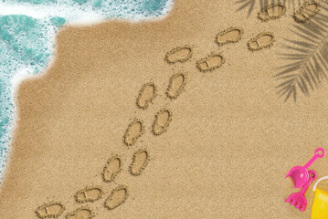 Fototapeta na wymiar Footprint on sandy beach, walking on sand concept, palm shadow and sea wave and toys composition, top view of sand beach, summer times trip idea