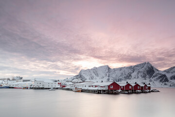 Landscape with snow mountains and seaside cabin