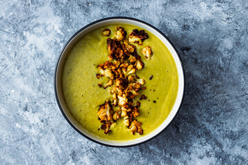 vegan homemade creamy broccoli soup with roasted cauliflower topping, healthy plant-based food