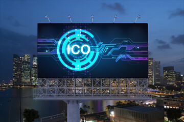 ICO hologram icon on billboard over panorama city view of Singapore at night time. The hub of blockchain projects in Southeast Asia. The concept of initial coin offering, decentralized finance