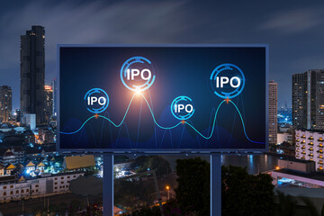 IPO icon hologram on road billboard over night panorama city view of Bangkok. The hub of initial...