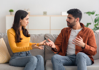 Angry Arabic Spouses Having Quarrel Arguing Sitting On Couch Indoor