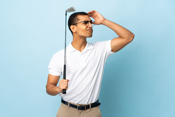 African American man over isolated blue background playing golf and and having doubts confuse face expression