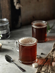 Still life composition with two glass mugs black tea on textured background
