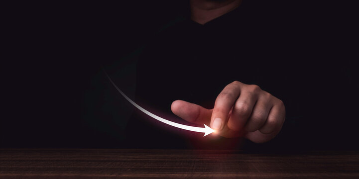 Decline graph. Economy crisis, global financial business risk and inflation, population declining concept. The virtual down arrow draws by businessman's finger on empty wood table on dark background.