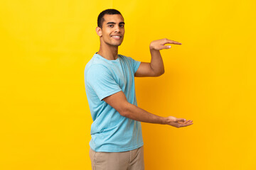 African American man over isolated background holding copyspace to insert an ad