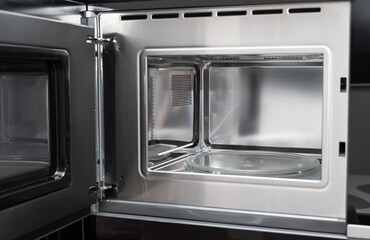 new clean stainless microwave built in with grill. modern kitchen appliance. selective focus