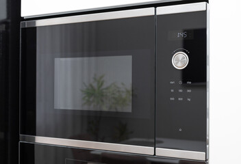 dark glass microwave oven built in with touch control and time display. modern kitchen furniture - obrazy, fototapety, plakaty