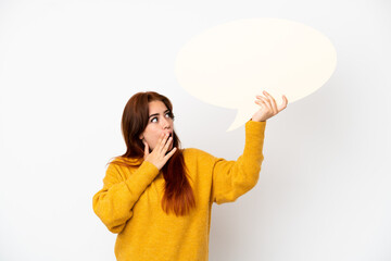 Young redhead woman isolated on white background holding an empty speech bubble with surprised expression