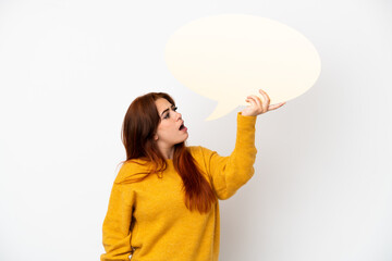 Young redhead woman isolated on white background holding an empty speech bubble
